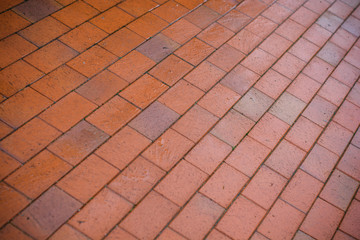 Fototapeta premium Red brick walkway in the rain, wet surface