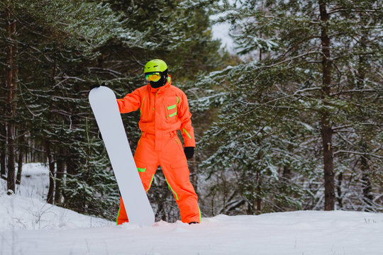 Snowboarder posing in winter forest