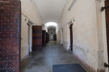 Fototapeta premium Blick in einen Gefängnis-Zellentrakt mit teilweise geöffneten Massivholztüren / Zellen