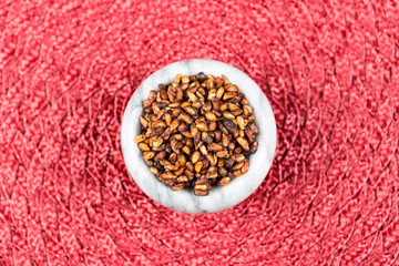 Pile of dried pomegranate seeds on a cloth background