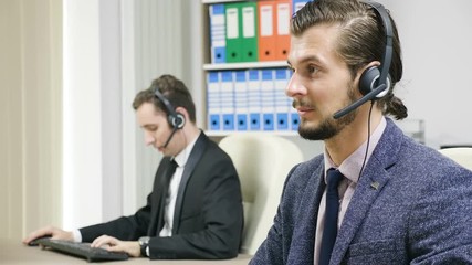 Customer support line worker using headset to talk on the hot line with customers