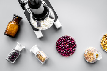 Food analysis process. Rice under microscope, red beans and wheat in petri dishes on grey...