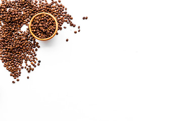 Fresh roasted coffee beans in bowl on white table top view copyspace. Coffee background.