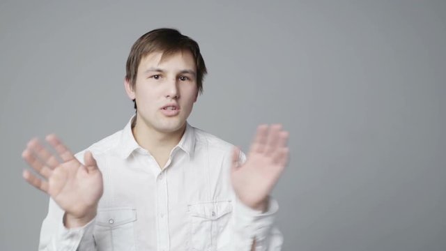 Negating Man gesturing and telling No, over grey background