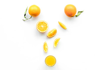 Orange juice in glass near slices of oranges on white background top view copyspace
