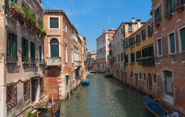 Traditional narrow canal street with gondolas and old houses in Venice, Italy. Architecture and landmarks of Venice. Beautiful Venice postcard.