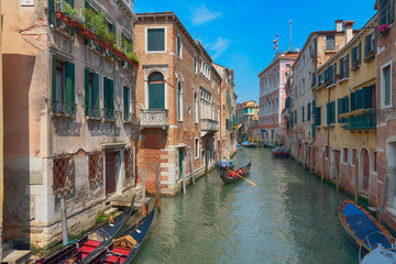 Traditional narrow canal street with gondolas and old houses in Venice, Italy. Architecture and landmarks of Venice. Beautiful Venice postcard.