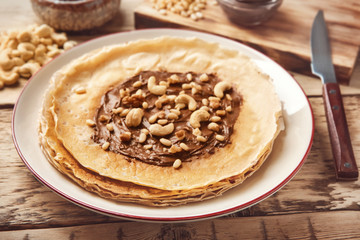 Plate with tasty buckwheat thin pancakes on table