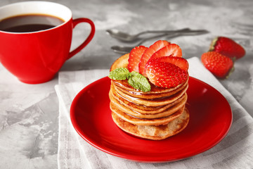 Plate with tasty buckwheat pancakes on table