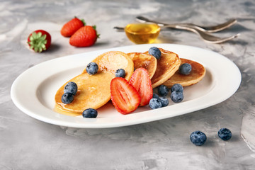 Plate with tasty buckwheat pancakes on table