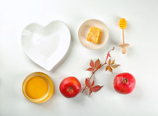 Composition with honey, apple and pomegranate for Rosh Hashanah holiday on white background, top view
