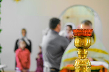 Church floor candlestick with a burning candle close-up. Kandilo in the Orthodox Christian church. Background with selective focus.