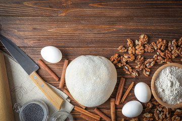Composition with raw puff pastry and ingredients on wooden table