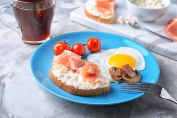 Plate with tasty toast, bacon, egg and vegetables on table, closeup
