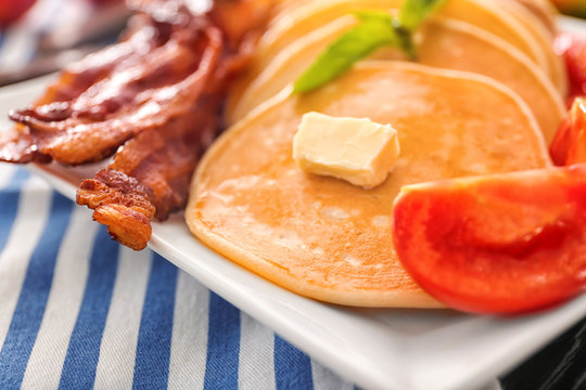Plate with pancakes, tomato and bacon, closeup