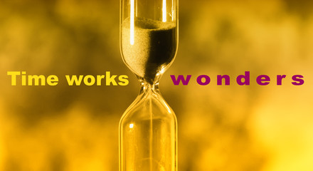 glass hourglass is pouring out the sand expires time. Time works wonders