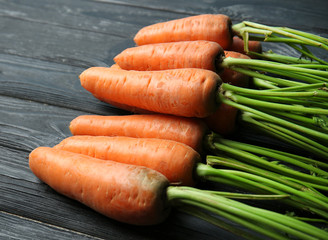 Tasty ripe carrots on wooden background