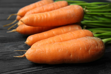 Tasty ripe carrots on wooden background