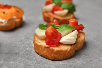Tasty bruschetta with tomatoes on grey background, closeup