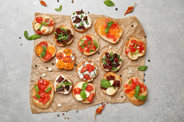 Tasty bruschettas with tomatoes on grey background