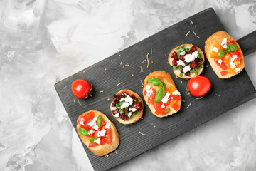 Tasty bruschettas with tomatoes on grey background