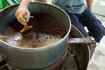 A farmer makes raw cocoa handmade with a machine at home. Can Tho city, Vietnam