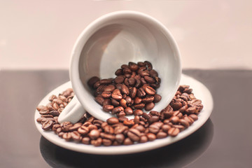 Closeup view of white cup with coffee beans