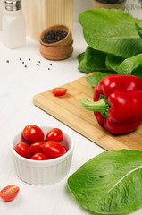 Fresh raw spring vegetables closeup on soft white wood table.