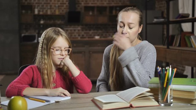 Bored girl unwilling to do homework with mother