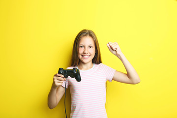 Portrait of beautiful girl with joystick on yellow background