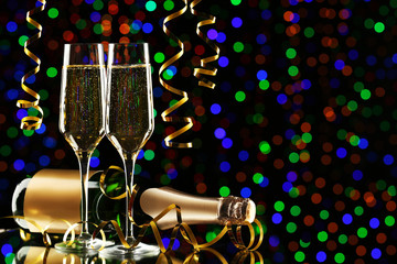 Champagne bottle with glasses on lights background