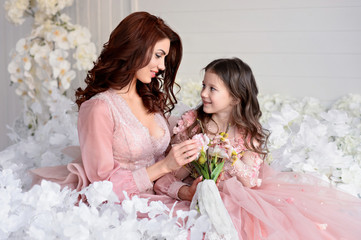Mom and daughter in amazing dresses with flowers