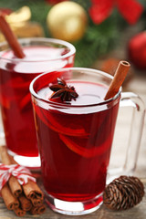 Mulled wine in glasses with spices on wooden table