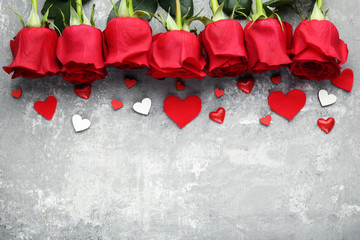 Bouquet of roses with red and white hearts on grey wooden table