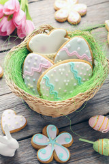 Fototapeta na wymiar Easter cookies in basket on grey wooden table