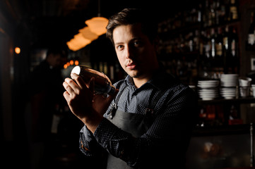 Barman in bar interior shaking and mixing alcohol cocktail