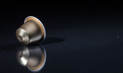 Espresso coffee pod isolated on black background, Closeup view with details, copy space