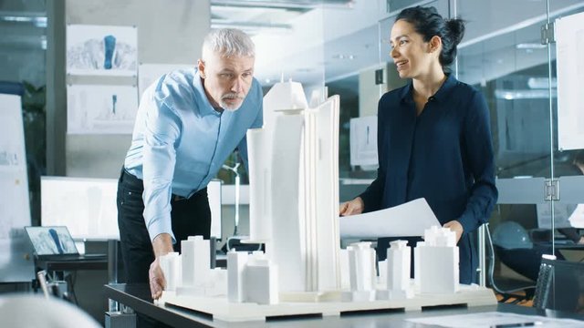 In the Architectural Bureau Two Engineers Work on a Model of a City District. Urban Planners Work on a Functional Building Model. Shot on RED EPIC-W 8K Helium Cinema Camera.