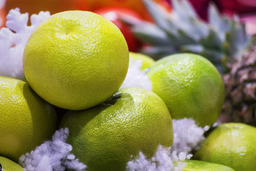Large, delicious, mouth-watering pomelo on the background of other fruits