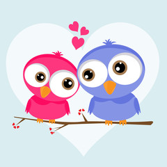 Two loving owls, happy birds are sitting on a tree.