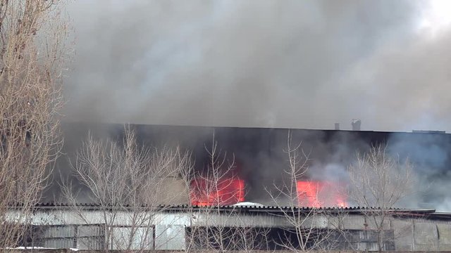 Fire in an industrial warehouse on Lantenskaya Street in Voronezh, Russia, rubber is burning, lots of smoke and flames, firefighters and MES rescue workers are struggling with a fire
