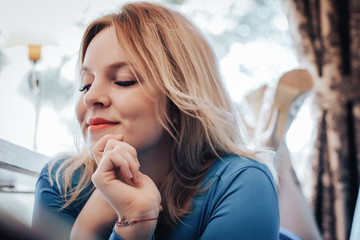 Blond woman in blue dress in cafe