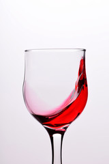 Glasses with waves plash of red wine on a white background