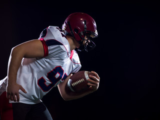 American football player holding ball while running on field