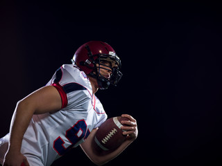 American football player holding ball while running on field