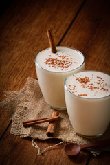 Eggnog houmemade with cinnamon and kakao for Christmas and winter holidays or wooden broun backgrounds