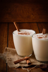 Eggnog houmemade with cinnamon and kakao for Christmas and winter holidays or wooden broun backgrounds