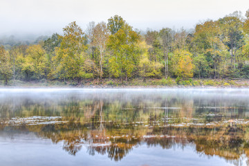 New River Gorge water river lake during autumn golden orange foliage in fall by Grandview with peaceful calm tranquil morning bright mist fog