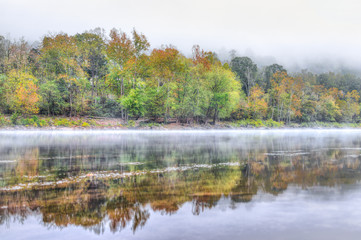New River Gorge water river lake during autumn golden orange foliage in fall by Grandview with peaceful calm tranquil morning bright mist fog