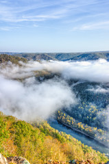 Mountains and fog, mist clouds in morning floating above forest trees, covering, blanketing valley in Grandview Overlook, West Virginia